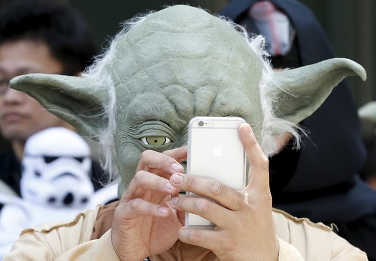  El personaje de Yoda consulta el móvil, en Tokio.