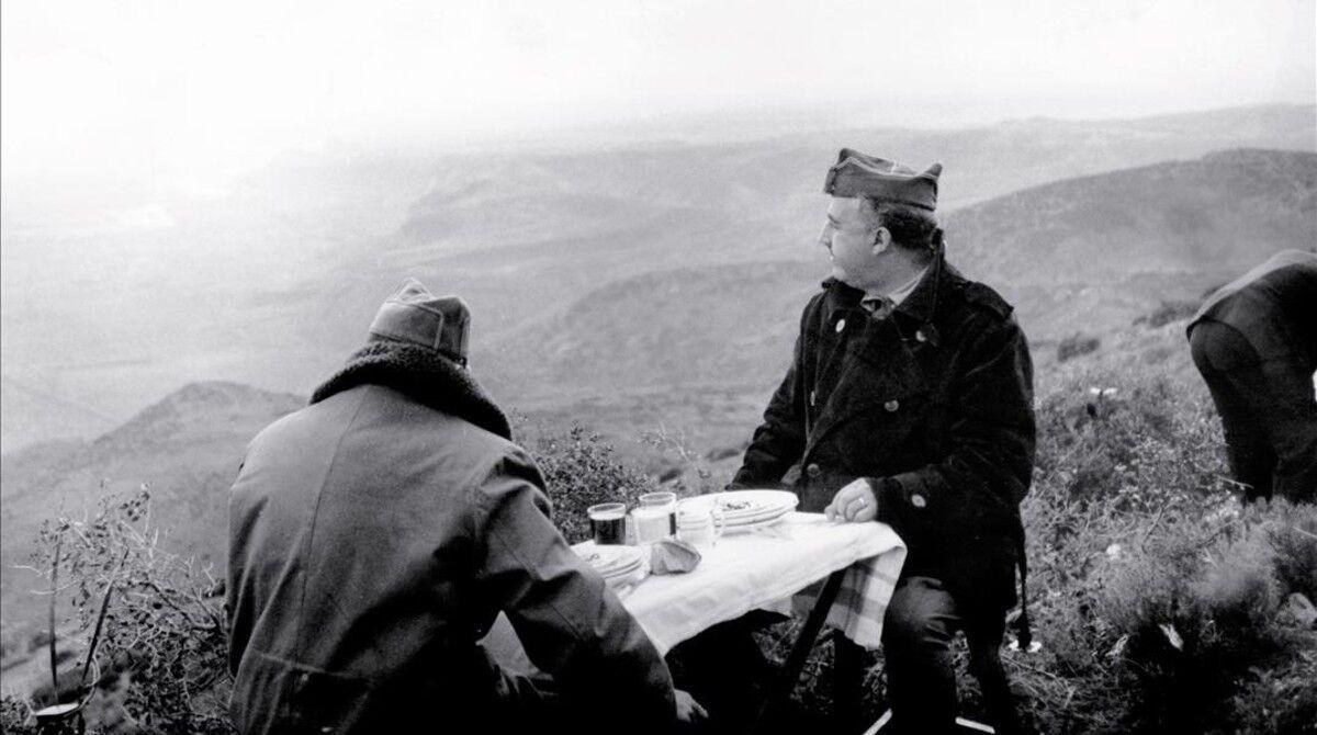 Francisco Franco y el general Fidel Dávila (de espaldas), jefe del Ejército del Norte, comen desde un puesto de mando situado en el Coll del Moro durante la batalla del Ebro, entre octubre y noviembre de 1938, hacia el final de la Guerra Civil.