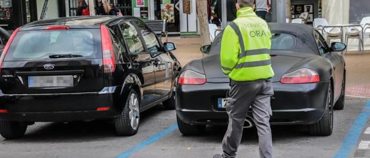 Un agente de la ORA comprueba que los vehículos aparcados en zona azul en la Plaza San Sebastián no se han excedido del tiempo.