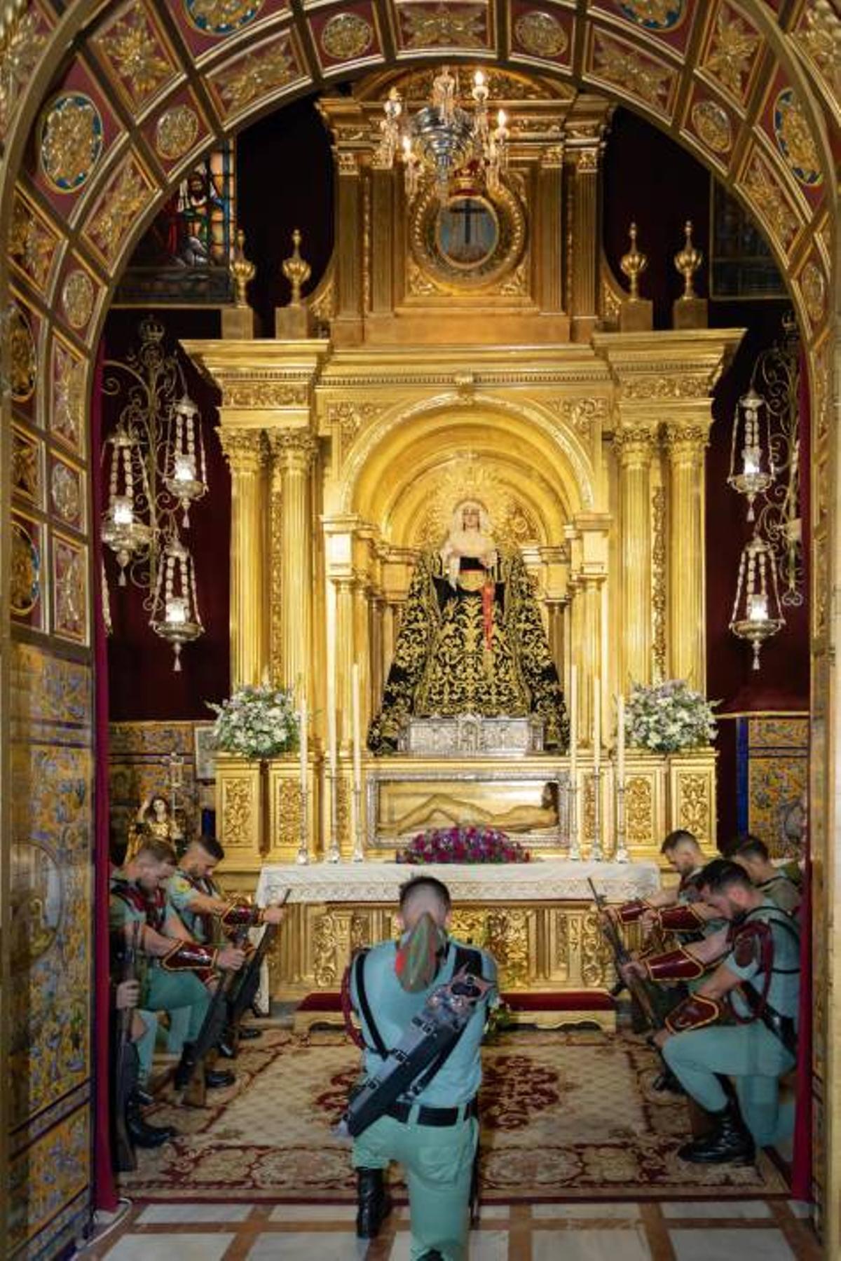 Gastadores de La Legión postrados ante los titulares de la hermandad de la Soledad en su visita a Alcalá del Río en 2021 con motivo de los actos del XXV aniversario de la coronación canónica de la Virgen