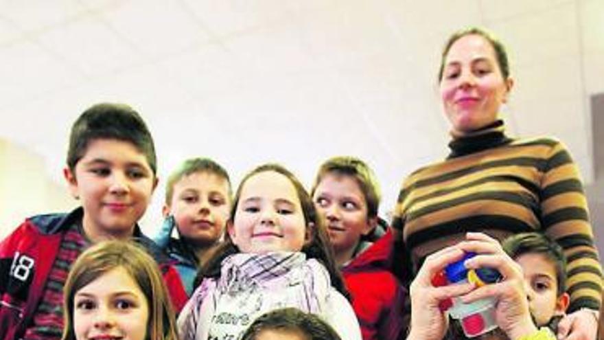 Un grupo de niños del Colegio Poeta Ángel González enseña los tapones.