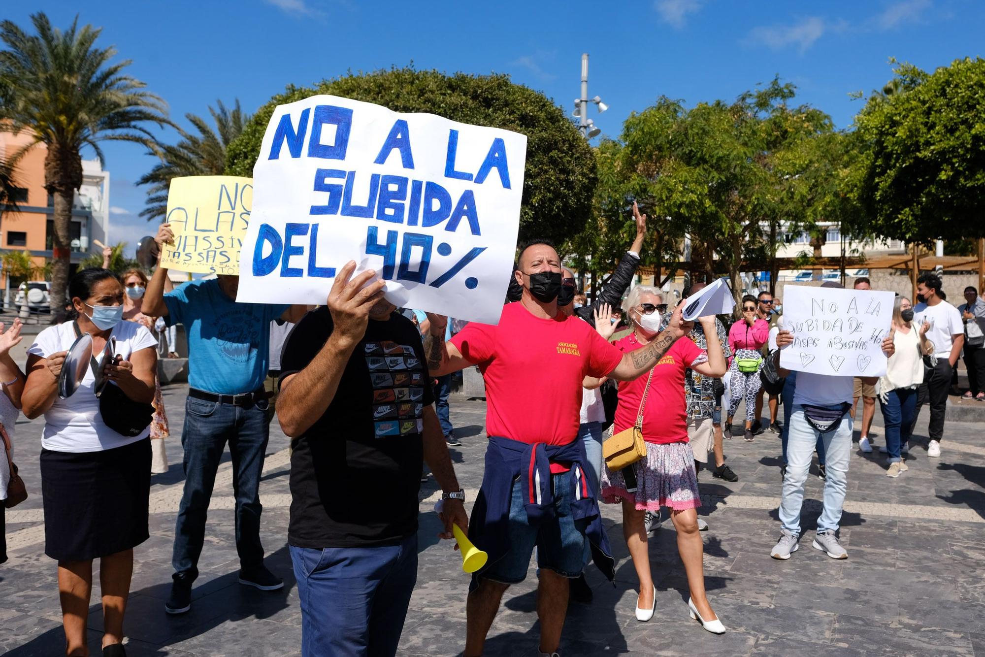 Uno de los puesteros participantes en la cacerolada muestra una pancarta contra la subida de las tasas municipales.