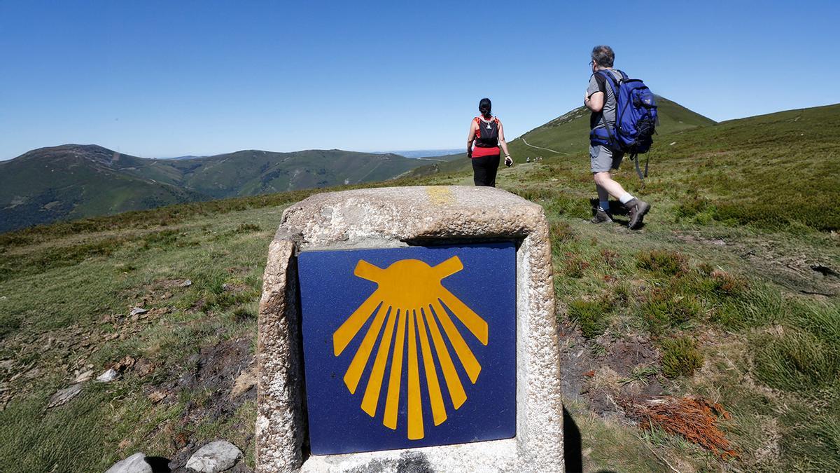 La venera guía a dos peregrinos que llegan al puerto de La Marta, en el tramo de Pola de Allande a Berducedo por Hospitales.