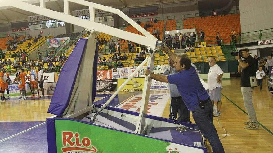 Un encargado del mantenimiento del Paco Paz intenta arreglar la canasta el pasado domingo.