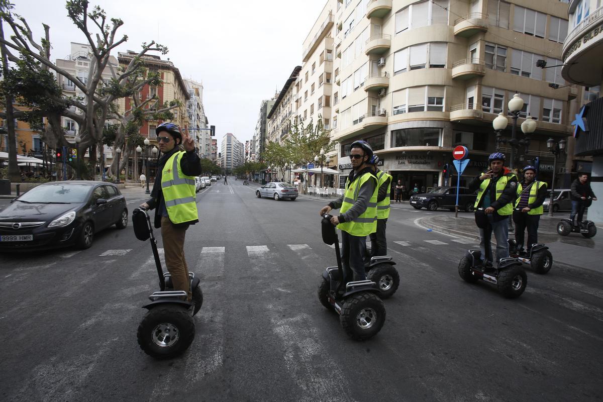 Varios turistas montados en segway cruzan por la Rambla.