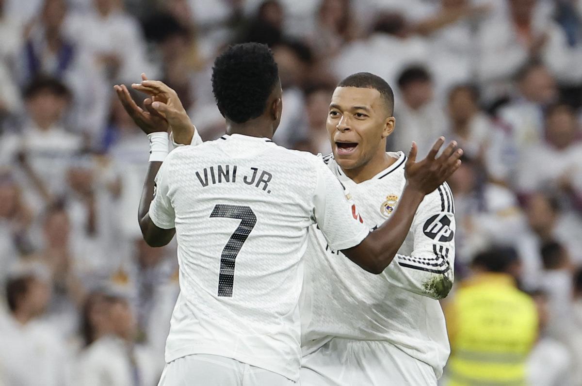 El delantero del Real Madrid Vinicius (izda) celebra con Kylian Mbappé el gol del empate ante el Valencia. EFE/Chema Moya. real madrid . valencia. liga españa 2024/2025 real madrid . valencia. 30. accion. santiago bernabeu