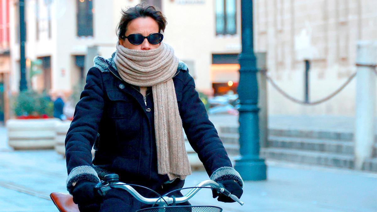 Una mujer en bici por una ciudad española.