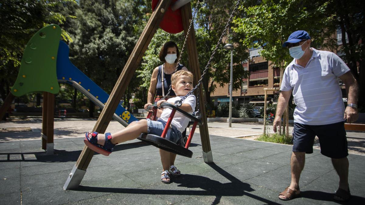 Un niño juega en un parque, que han reabierto tras tres meses cerrados por seguridad.