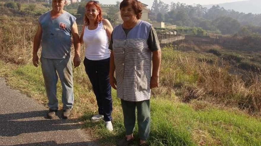 Los Acevedo, ante unas fincas quemadas en A Nogueira. // J.L.