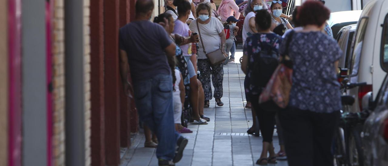 Cientos de personas acuden al economato de Tómbola, donde algunos consiguen alimentos gratis y otros pagan precios bajos.