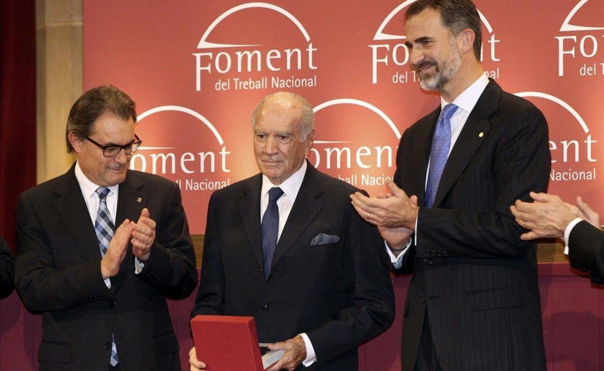 El rey Felipe VI,  junto al presidente de la Generalitat Artur Mas, tras entregar la Medalla de Honor a la Trayectoria Empresarial a Mariano Puig, en diciembre del 2014.