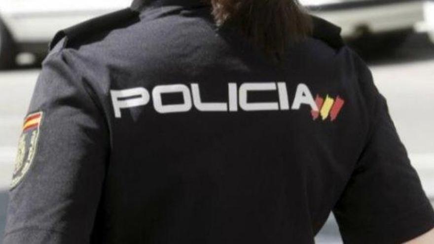 Un agente de la Policía Nacional, de espaldas.