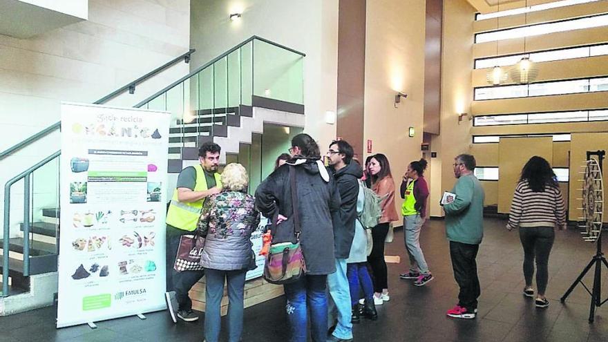 Ciudadanos informándose sobre la campaña de reciclaje en el centro municipal de El Llano. | Imagen cedida a LNE