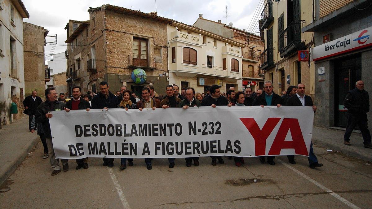 Líderes políticos de la época, como el alcalde Antonio Asín o el diputado Jesús Membrado (centro), portan la pancarta de la protesta en Mallén en 2004.