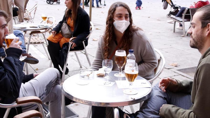 Uns joves prenen una cervesa en una terrassa a la plaça de la Virreina, el 23 de novembre del 2020