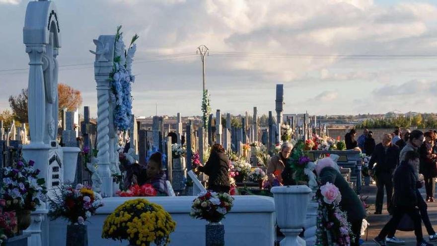 Trasiego de gente y sepulturas engalanadas durante la jornada previa a la festividad de Todos los Santos en el cementerio municipal de San Atilano.