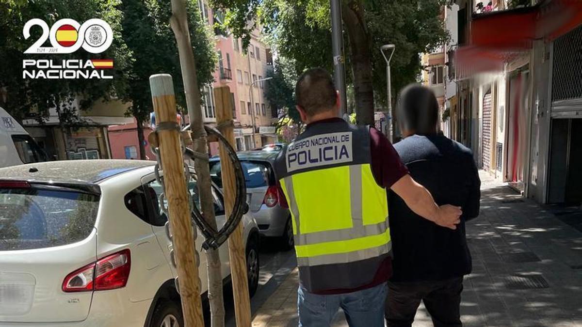 Un policía, con uno de los detenidos en la operación.