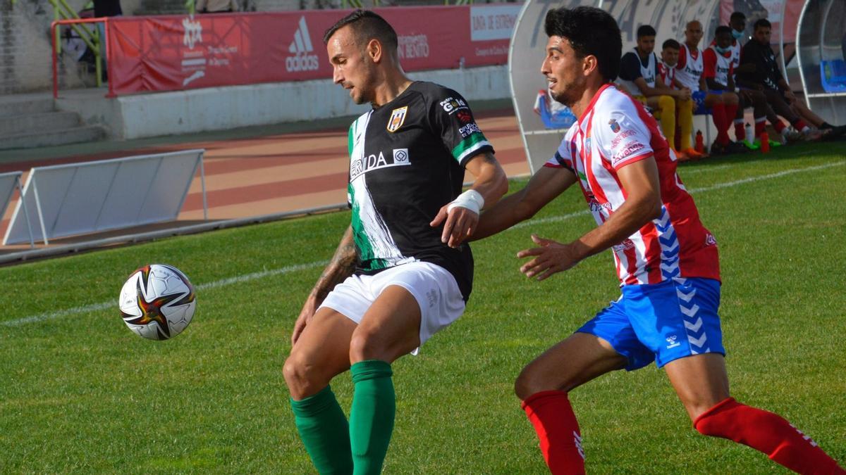 Aitor Pons, del Mérida, protege el balón ante el jugador del Don Benito Álex Herrera.