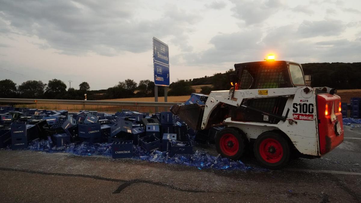 Una máquina retira las botellas rotas y las cajas.