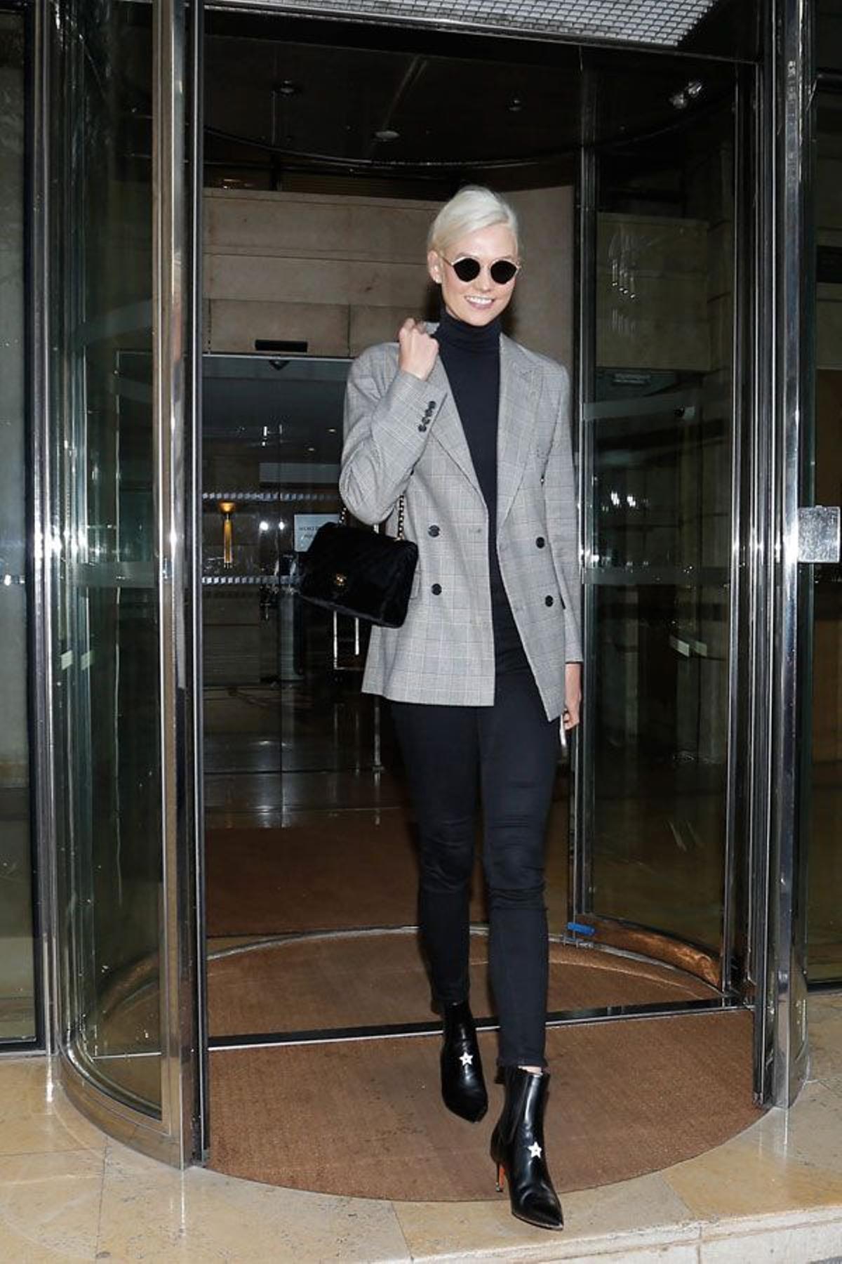 Karlie Kloss con look en negro, blazer de cuadros y botines con estrella