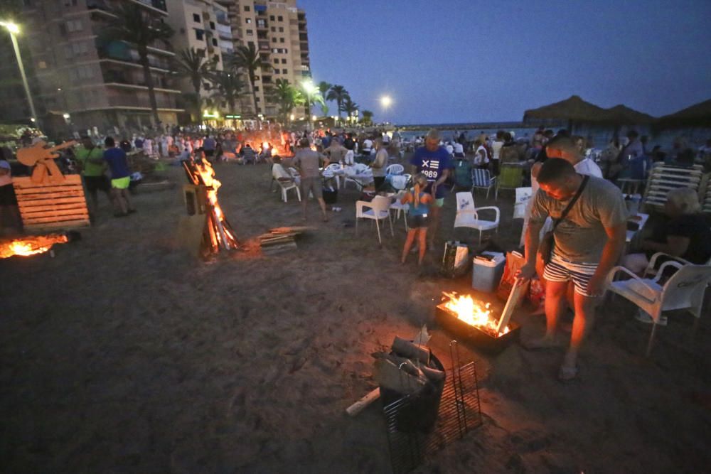 Noche de hogueras, baños, en las playas de la Vega Baja. En las imágenes grupos de amigos y familias en la playa del Cura de Torrevieja