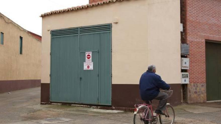 Un vecino pasa con su bicicleta por delante del pozo en el que se han detectado los nitratos.