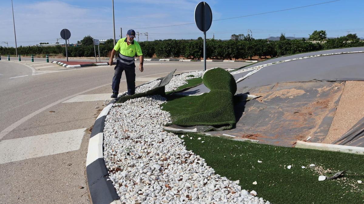 Un trabajador quita el poco césped que quedaba en la rotonda de Silla.