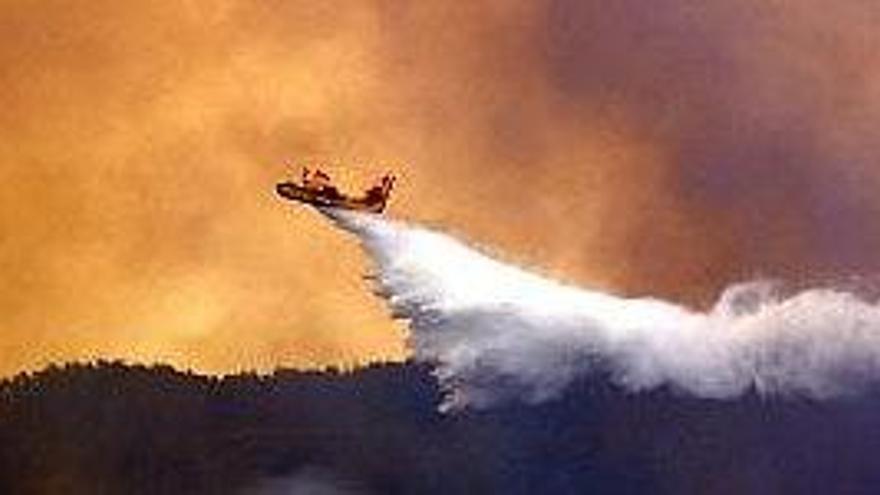 Un hidroavión de los bomberos griegos combate un incendio en un bosque de la Isla de Roda.