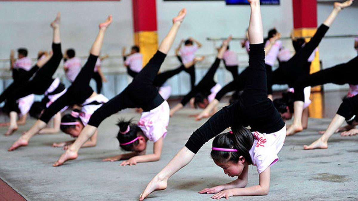 Un grup de nenes posa a prova la seva flexibilitat a l’escola d’acrobàcia de Shenyang a la Xina.