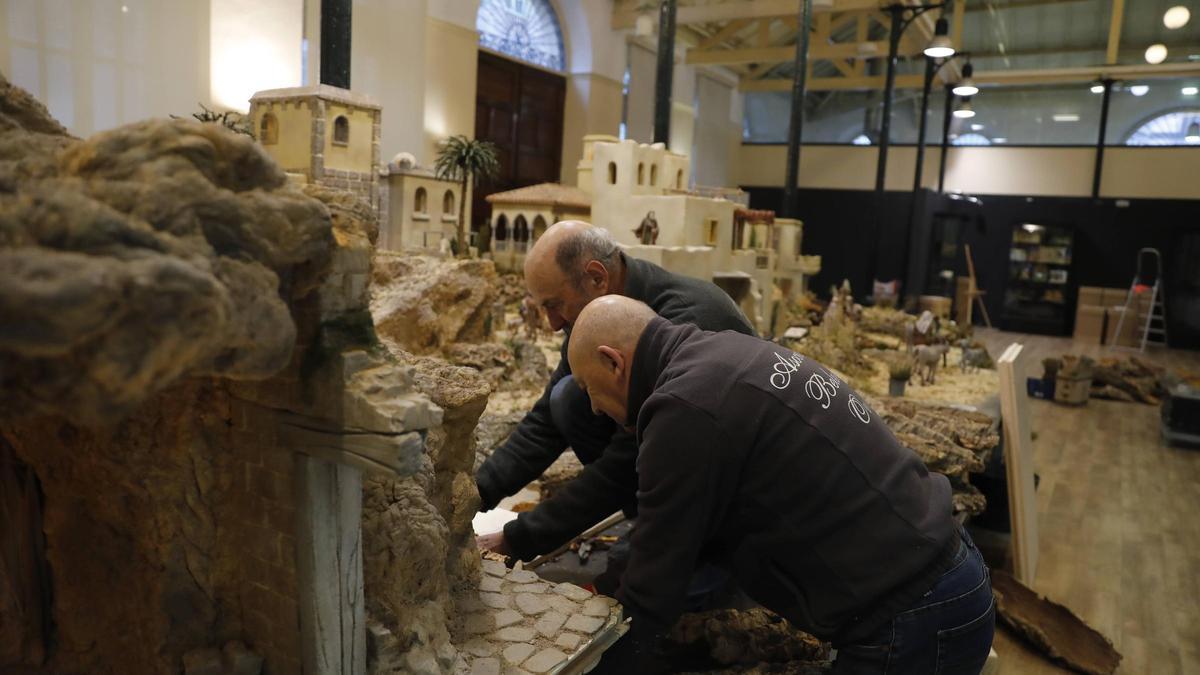 Los miembros del equipo de montaje preparan los últimos retoques antes de la inauguración del sábado.