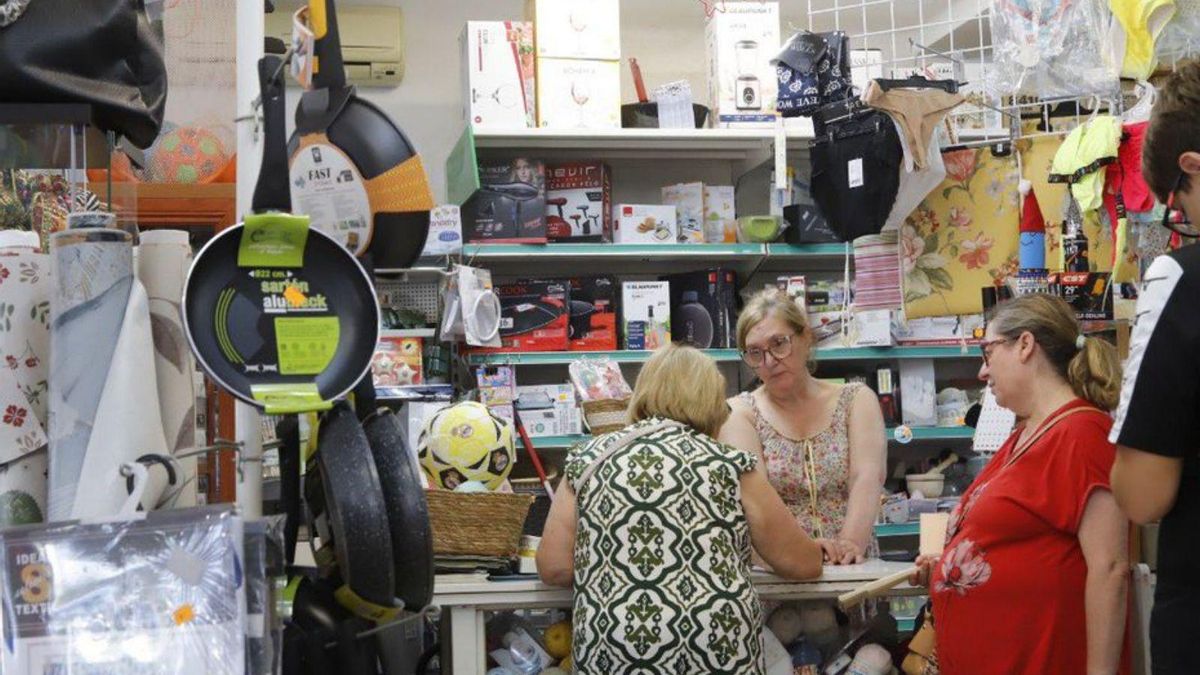 Ana Mari atiende a varias vecinas en su tienda de Cerro Muriano, que multiplica sus habitantes en verano.