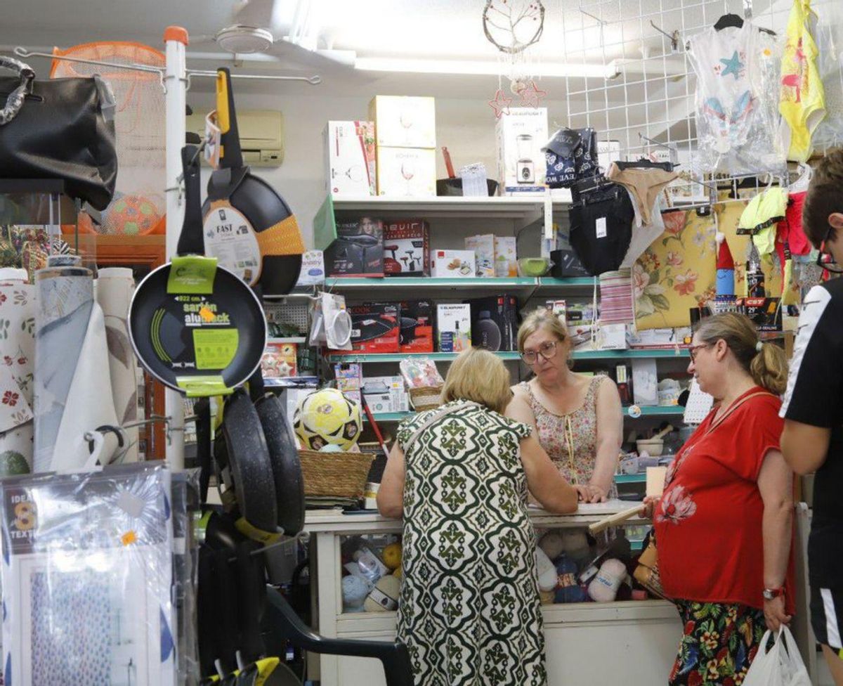 Ana Mari atiende a varias vecinas en su tienda del Muriano, donde vende un poco de todo.
