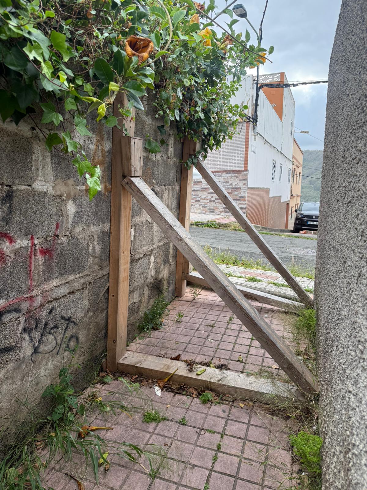 Callejón en mal estado junto a un muro apuntalado en Las Mesas