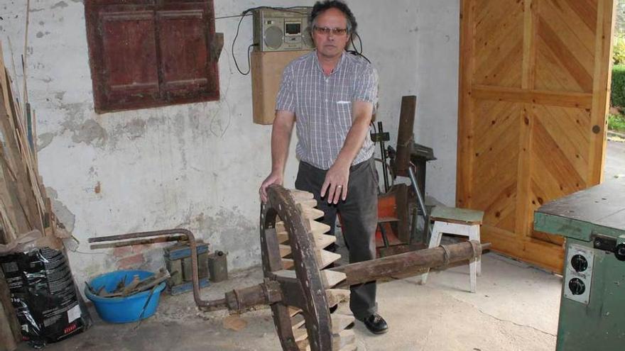 Pedro Suárez con la rueda del molino restaurada en un taller particular de Huexes.