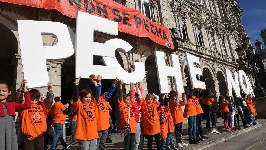 Niños con camisetas de Alcoa sostienen letras con el mensaje &#039;Peche non&#039; ante el Ayuntamiento.