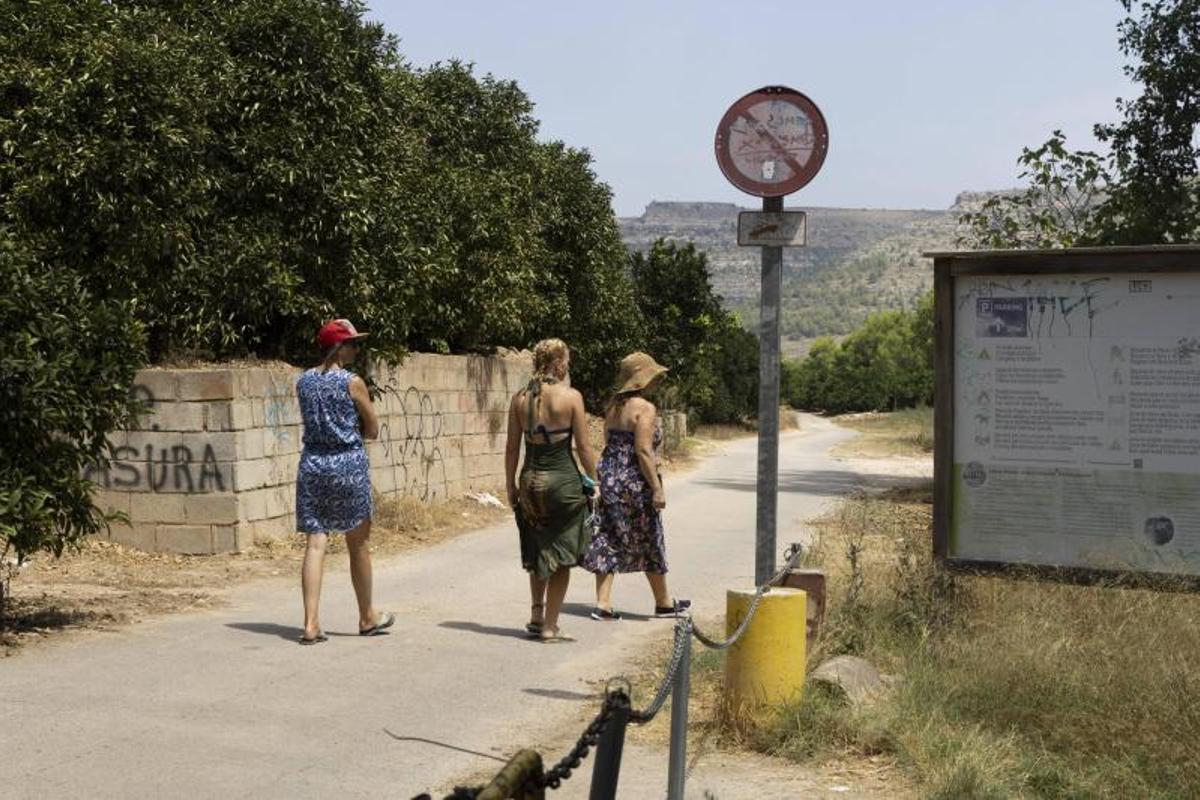 Tres bañistas buscan un acceso al Xúquer tras pasar por l'Esgoletja.