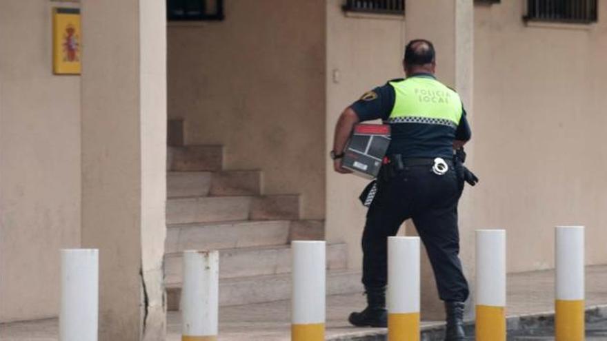 Un policía local llevaba ayer al cuartel de la Guardia Civil una caja con las diligencias practicadas en los últimos años por los agentes detenidos.