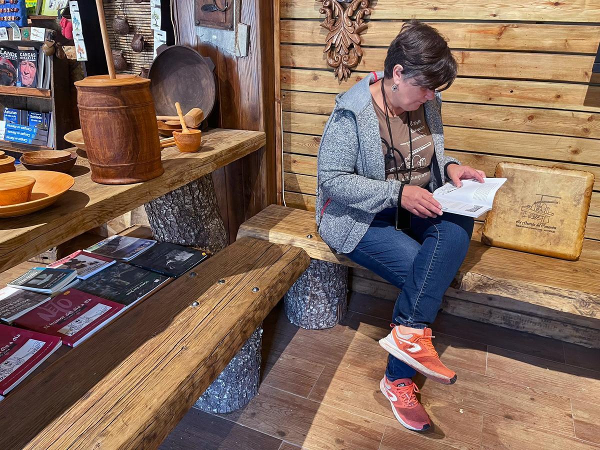Rosa Cunqueira consulta un libro en su tienda, La Guarida del Cunqueiru.