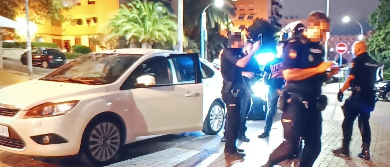 Agentes de la Policía junto al coche implicado en la persecución.