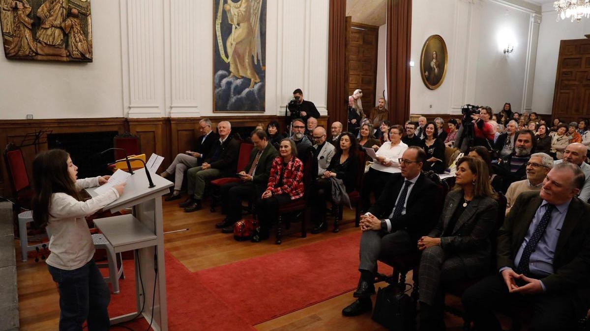 Una alumna del colegio Dolores Medio de Oviedo recita unos versos de "Una escuela es una casa" en la capilla universitaria.