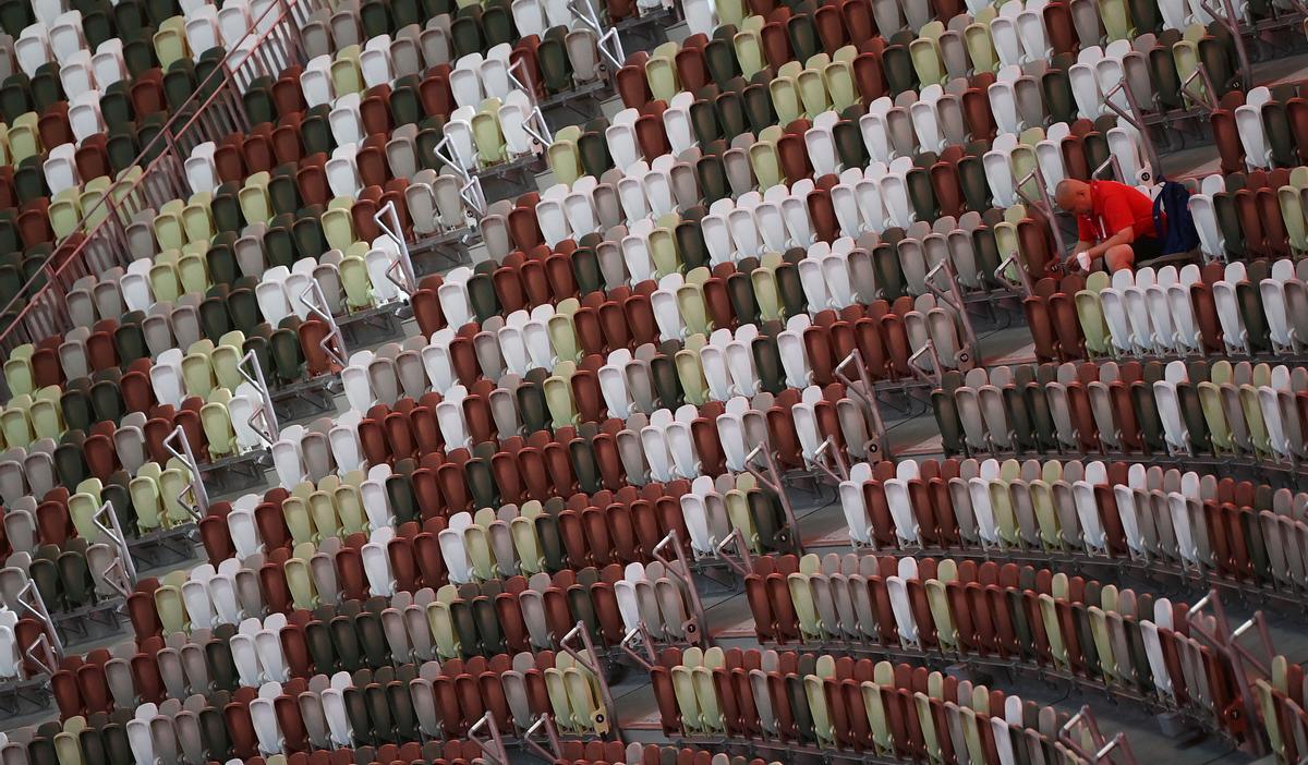 Un hombre se sienta en una grada vacía del estadio olímpico, durante la inauguración de los Juegos.