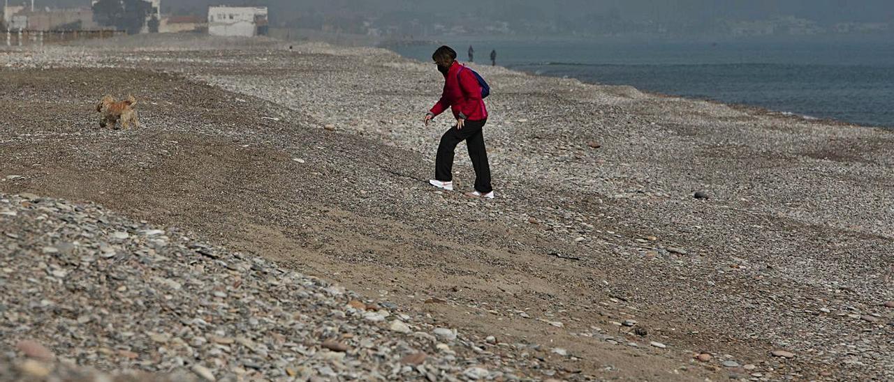 Un vecino, salvando el gran escalón en la playa de Corinto de Sagunt.  | TORTAJADA