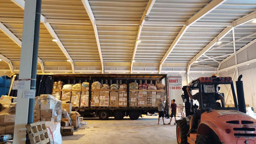 Carga de un tráiler con palés de objetos y material donados para Ucrania en un almacén de Alicante.