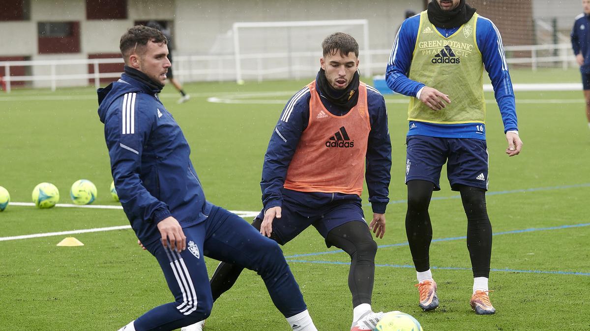 Álvaro Giménez da un pase con Lluís López a su lado.