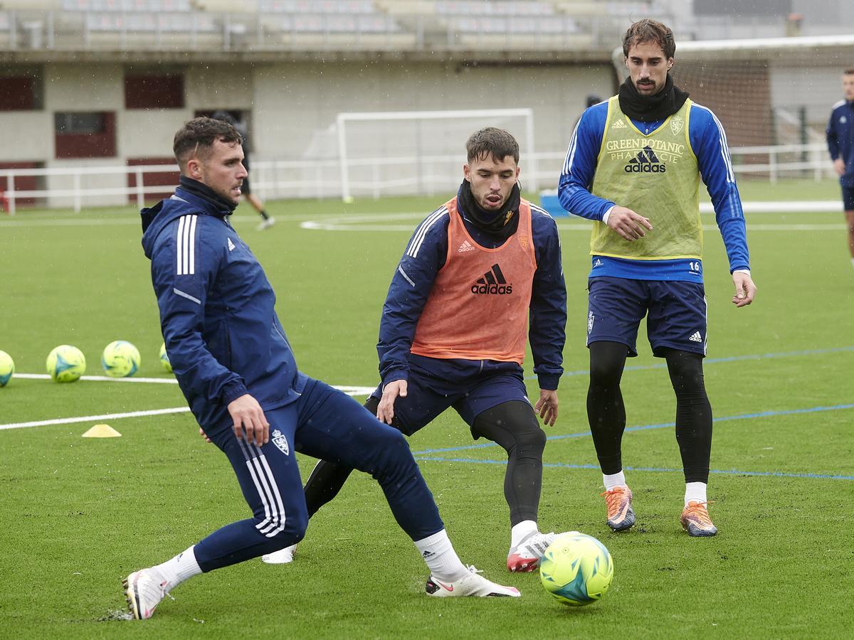 Álvaro Giménez da un pase con Lluís López a su lado.