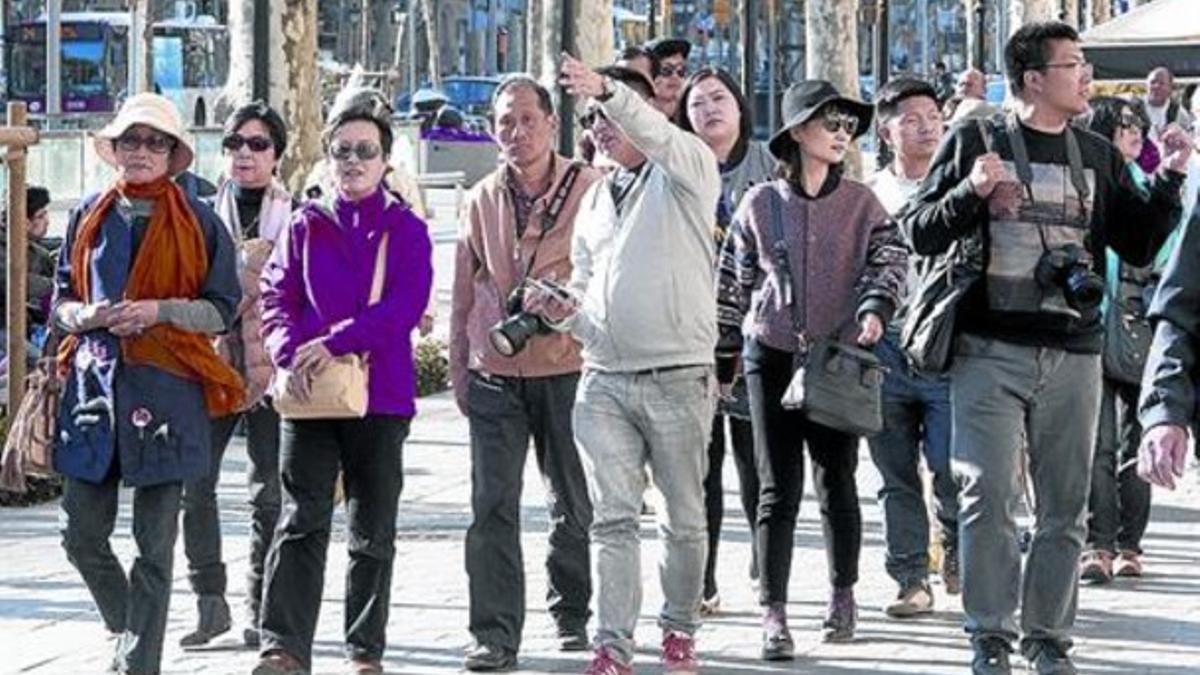 Un grupo de turistas pasea por el paseo de Gràcia.