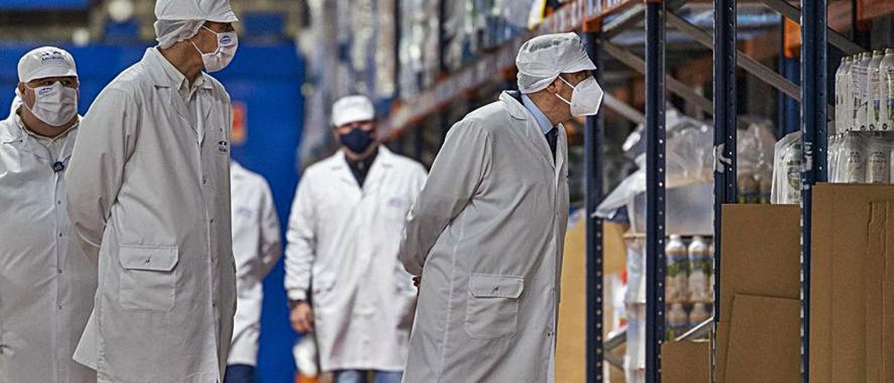 Luis Planas, a la derecha, observando envases de leche asturiana, el jueves, en la planta de Capsa en Granda (Siero). | Alberto Morante