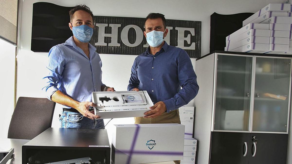 Guillermo Grau y Juan Antonio Ruiz, con el sistema para desinfectar billetes en las cajas registradoras. | MANUEL R. SALA