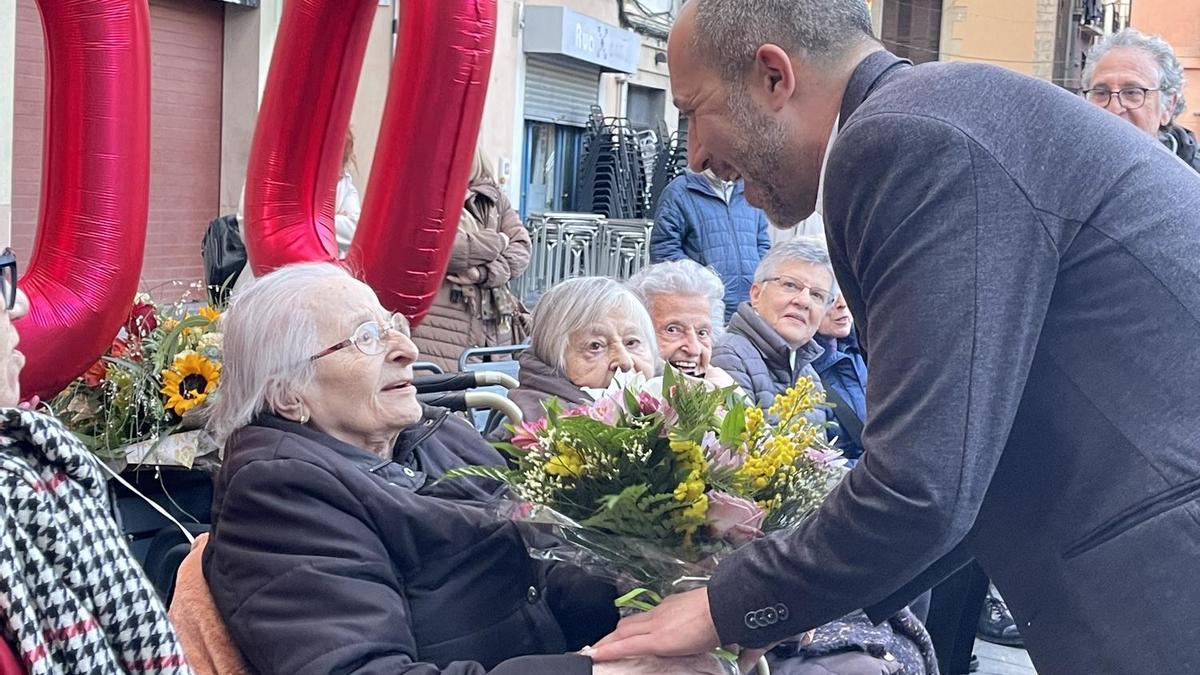 La centenària Carme Boix rep un ram de flors de mans de l'alcalde, Marc Aloy