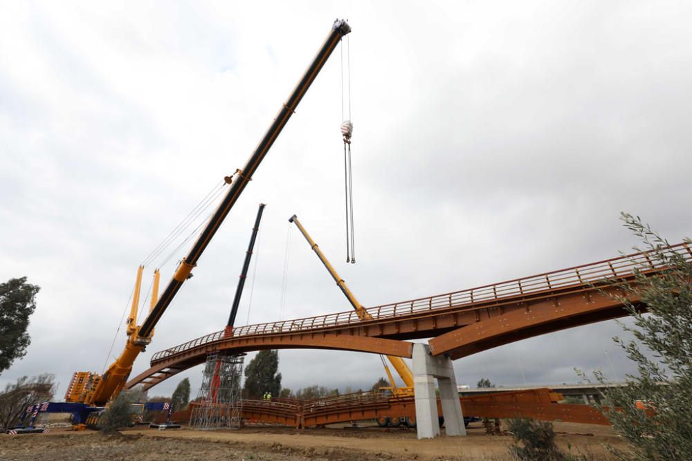 La instalación del último tramo del puente de madera sobre el río Guadalhorce ha comenzado este martes.